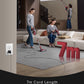 Two people using a vacuum cleaner with a 7m cord in a living room setting.