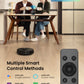 Two people sitting at a table with a robot vacuum cleaner and remote control, featuring smart control methods.