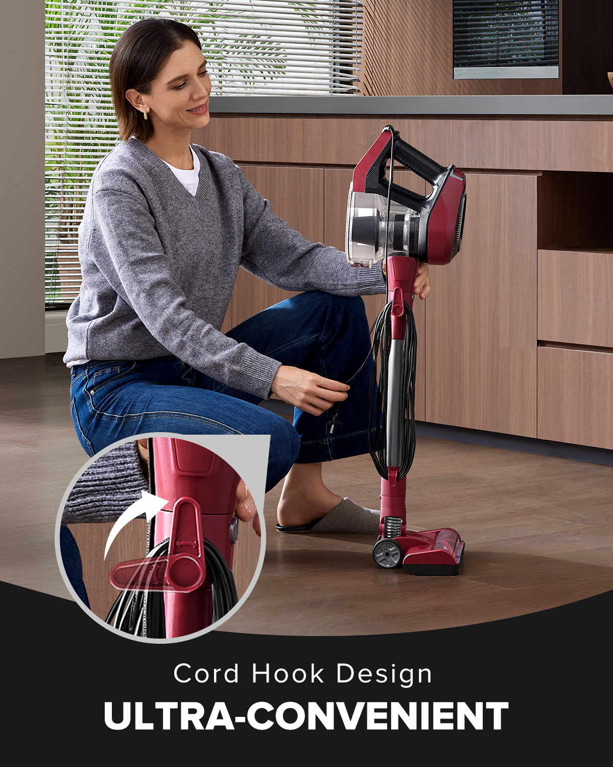 Woman using a red and black vacuum cleaner in a room with wooden flooring.